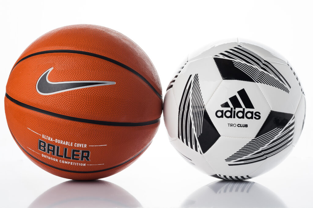 Two sports balls, one with Nike logo and one with Adidas logo