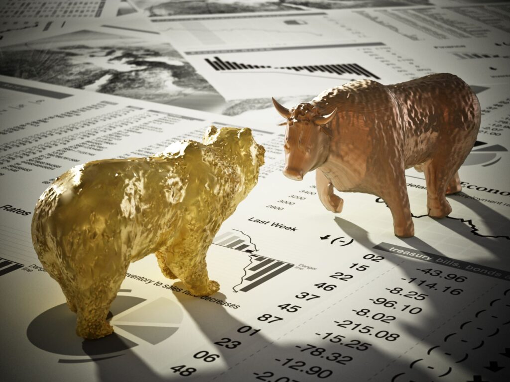 Bull and Bear images on top of Newspaper article stock quotes representing bull vs bear market cycle.